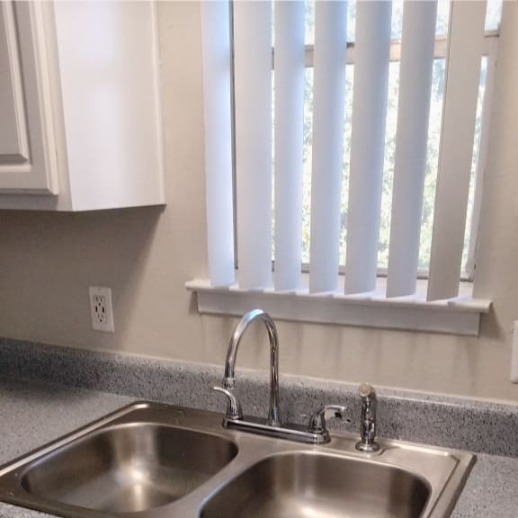 a stainless steel urinal in a kitchen with a window
