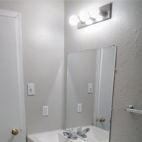 a bathroom with a sink and a mirror on the wall