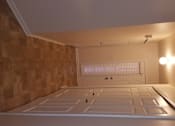 Thumbnail 17 of 41 - A room with a brown tiled wall and a white ceiling.
