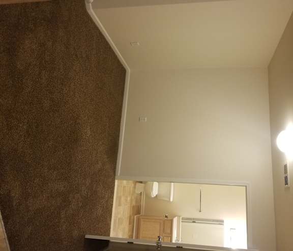 A small, empty room with a mirror on the wall.