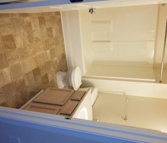 A bathroom with a toilet and a tiled wall.