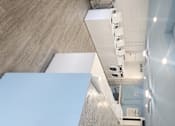 Thumbnail 14 of 17 - A long white table is in a room with a concrete wall.