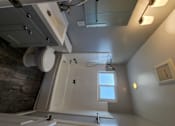Thumbnail 15 of 17 - a bathroom with a toilet and a sink and a window