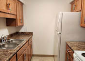 Thumbnail 6 of 18 - a kitchen with wooden cabinets and a stainless steel sink and a dryer