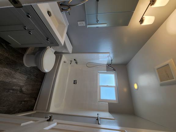 a bathroom with a toilet and a sink and a window