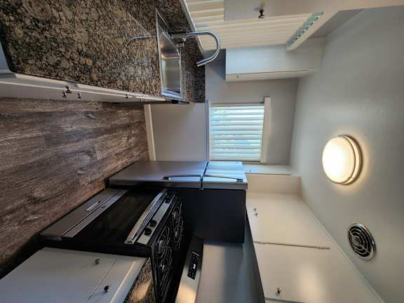 a kitchen with a sink and a counter top and a window
