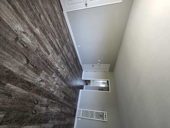a view down the hallway from the top of the stairs looking down to the floor