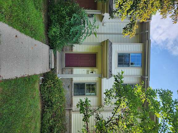 A house with a red door and a window with a curtain.