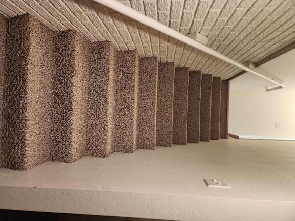 A room with a brown carpeted staircase.