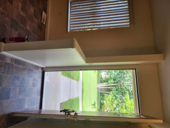 A window with blinds and a window sill.