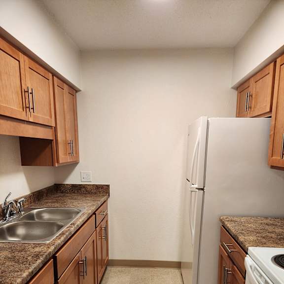 a kitchen with wooden cabinets and a stainless steel sink and a dryer