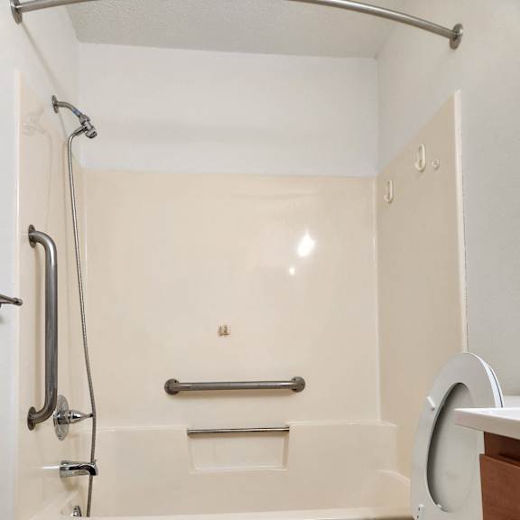 a white bathroom with a urinal and a sink and a mirror
