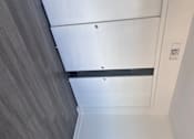 Thumbnail 19 of 24 - Fully-Furnished Townhomes in Corona, CA - Dos Lagos Townhomes - Closet With White Sliding Doors, Gray Wood-Style Flooring, Neutral Walls, Baseboard Trim, And An Overhead Air Vent.