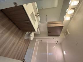 A modern bathroom with a wooden countertop and white walls.