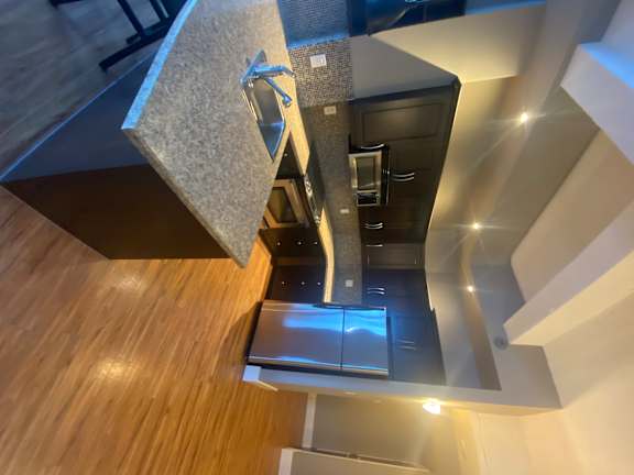 A modern kitchen with a wooden counter and stainless steel appliances.