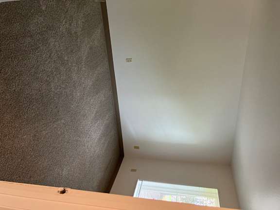 A corner of a room with a window and a wall.