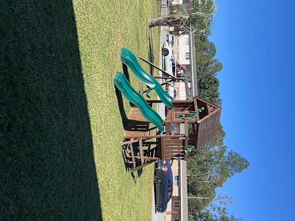 A playground with a slide and a wooden structure.