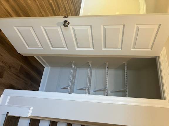 A white door with a silver handle is open.