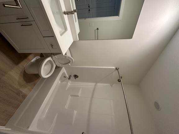 A white bathroom with a toilet and a shower.