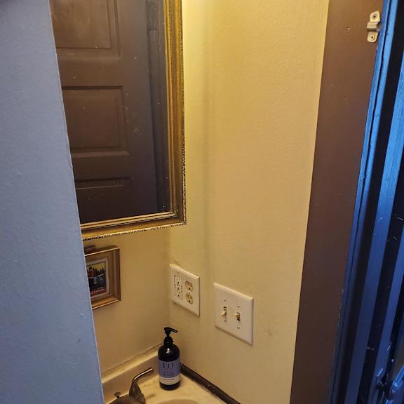 A bathroom with a toilet and a light on the ceiling.
