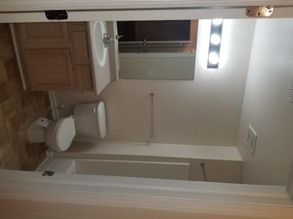 A white toilet is mounted on a wall in a room.