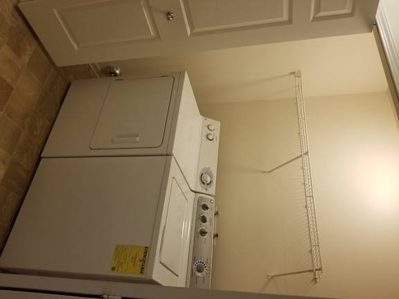 A white bathroom with a towel rack and a white cabinet.