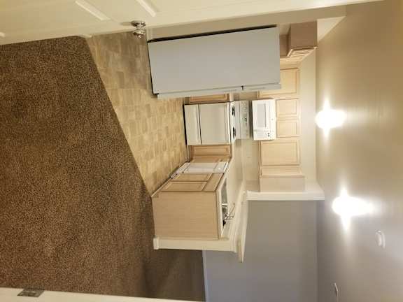 A modern kitchen with a white countertop and a wall-mounted oven.