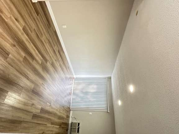 a long hallway with wood flooring and a window