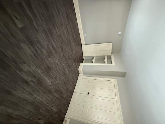 A white ceiling with a skylight and a grey floor.