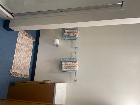 A bathroom with a towel rack and a toilet paper holder.