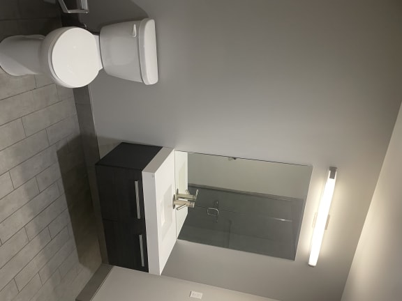 Large spacious bathrooms feature ample lighting, floating vanities, and large showers with full glass doors.