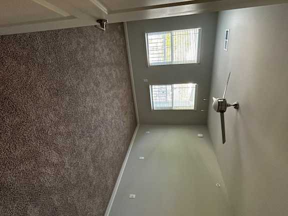 A bathroom with a ceiling fan and a window.
