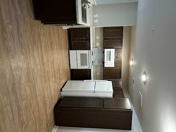 A kitchen with a refrigerator, microwave, and oven.
