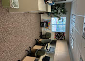 Thumbnail 8 of 14 - A room with a desk, chairs, and a bulletin board.