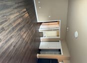 Thumbnail 31 of 48 - A modern kitchen with a wooden floor and white cabinets.