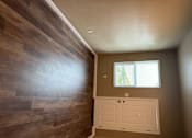 Thumbnail 41 of 48 - A room with a window and a wooden wall.