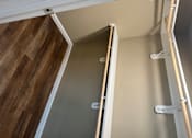 Thumbnail 27 of 48 - A white ladder with wooden handles is leaning against a wall.