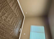 Thumbnail 25 of 48 - A room with a window and a brown carpet.