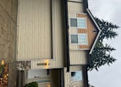 Thumbnail 43 of 82 - A house with a brown and beige exterior and a white garage door.