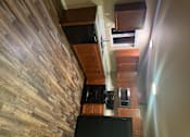 Thumbnail 22 of 48 - A kitchen with wooden cabinets and a black countertop.