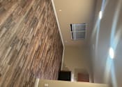 Thumbnail 23 of 48 - A wall of wood planks runs along the side of a room.