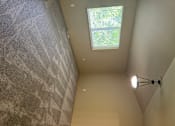 Thumbnail 18 of 82 - A small window in a room with a light on the ceiling.