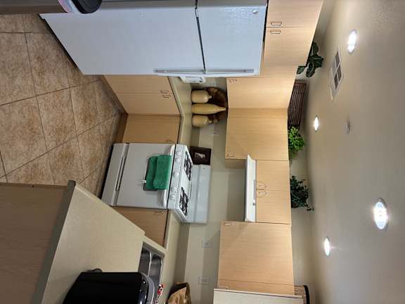 A kitchen with a white fridge and wooden cabinets.