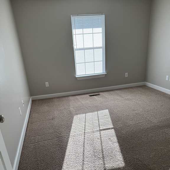 A room with a window and a wall with a shadow of a window.