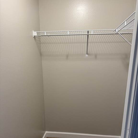 A room with a white wall and a brown board on the right side.