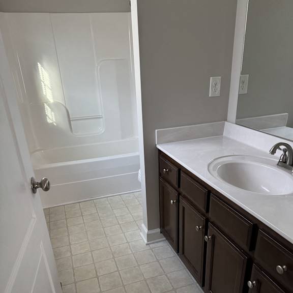 A white bathroom with a white tub and a white toilet.