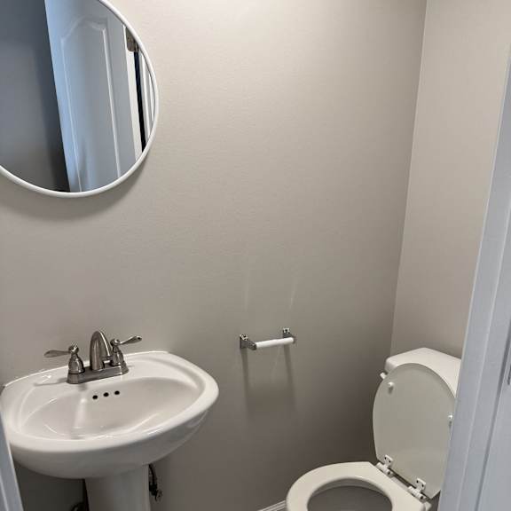 A white toilet with a white sink and a white wall.