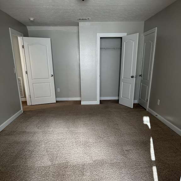 A kitchen with a white fridge and a white cabinet.