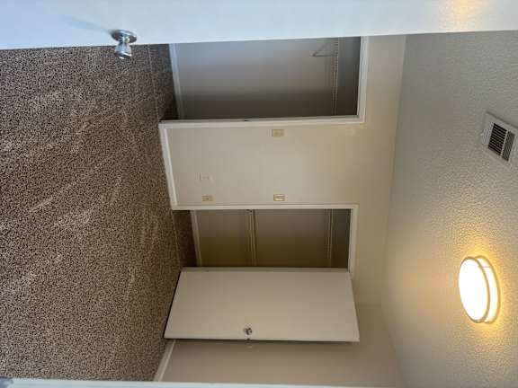 A white refrigerator in a room with a brown wall and a white ceiling.