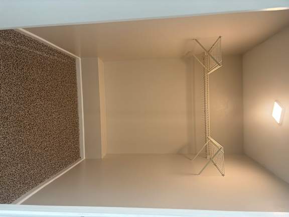 A white room with a brown carpet.